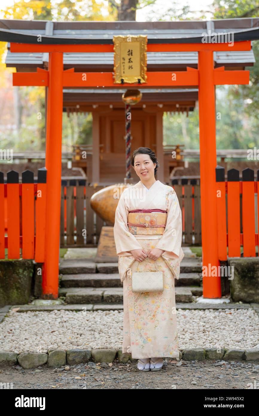 Japanische Kimono-Porträtfotografie. Kyoto, Japan. Traditioneller japanischer Schrein Torii im Hintergrund. Stockfoto