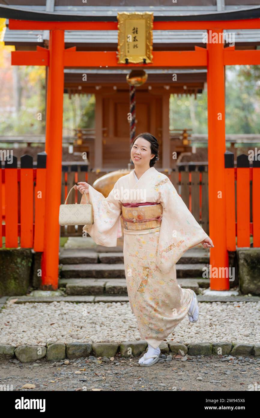 Japanische Kimono-Porträtfotografie. Kyoto, Japan. Traditioneller japanischer Schrein Torii im Hintergrund. Stockfoto