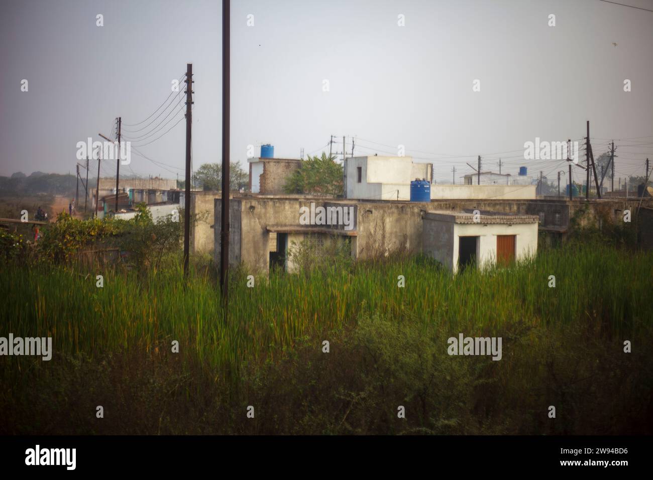 Das Foto zeigt eine Szene des bescheidenen Lebens in einem ländlichen Dorf in Chattisgarh, Indien. Die Häuser sind einfache Bauten aus Schlamm und Ziegeln. Stockfoto