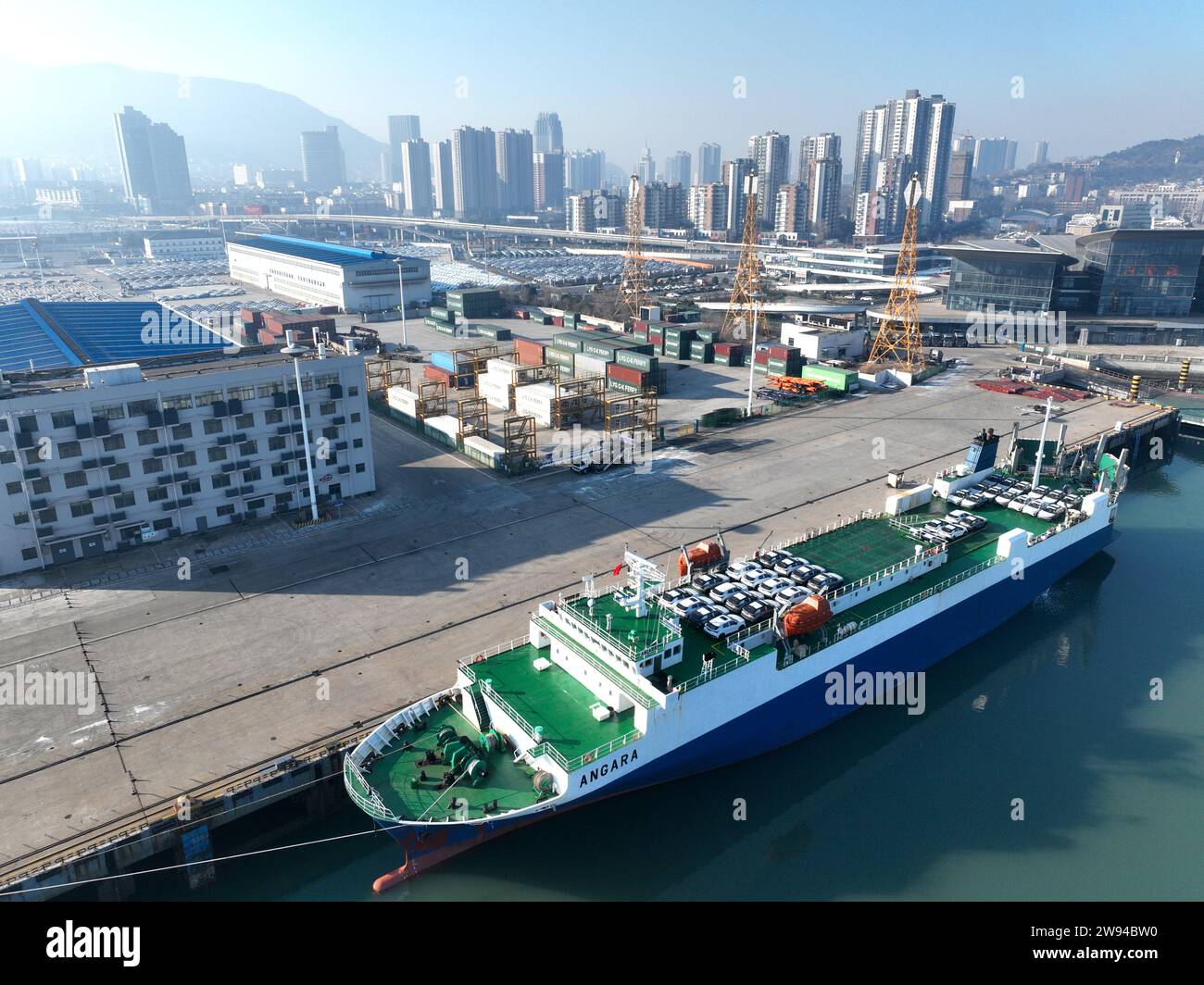 LIANYUNGANG, CHINA - 24. DEZEMBER 2023 - Rollräder laden Autos für den Export an einem Dock in Lianyungang, Provinz Jiangsu, China, 24. Dezember 2023 Stockfoto