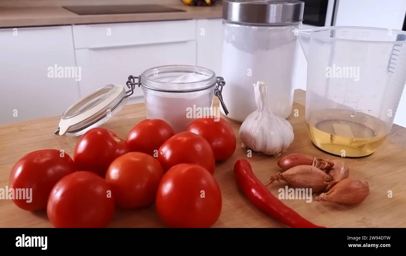 Frische Tomaten mit Chilies Zwiebeln Knoblauchmehl und Gläsern wunderschön auf einem Holztisch angeordnet Stockfoto