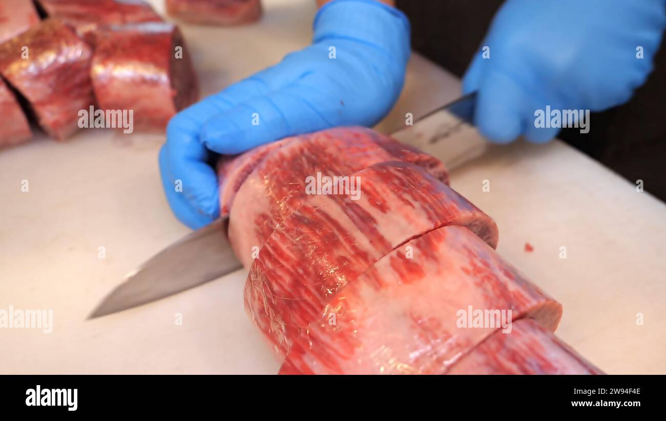 Premium-Rindfleisch – ein erfahrener Koch schneidet hochwertige Rindfleisch-Schnitte mit Präzision. Kulinarische Exzellenz trifft auf Präzision in diesem atemberaubenden Rindfleischblock Stockfoto