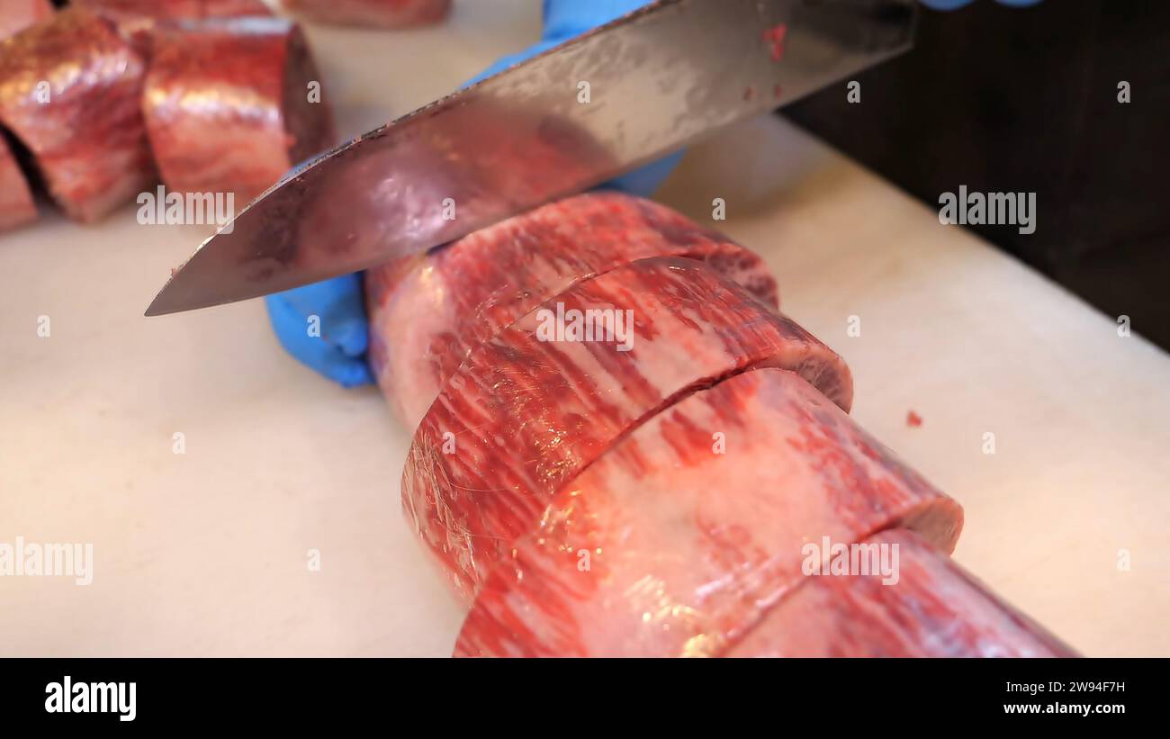 Premium-Rindfleisch – ein erfahrener Koch schneidet hochwertige Rindfleisch-Schnitte mit Präzision. Kulinarische Exzellenz trifft auf Präzision in diesem atemberaubenden Rindfleischblock Stockfoto