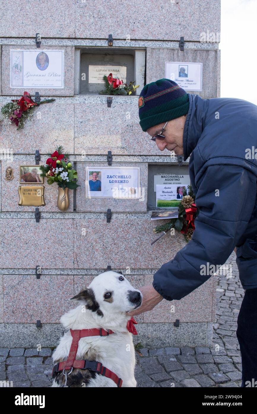 Hund und Hundebesitzer vor dem Grabstein eines Verwandten Stockfoto