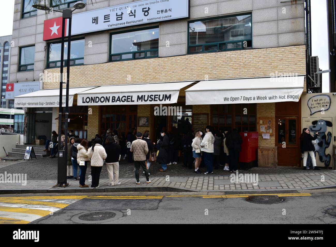 Einheimische koreanische Paare und Leute warten in der Schlange im London Bagel Museum Stockfoto
