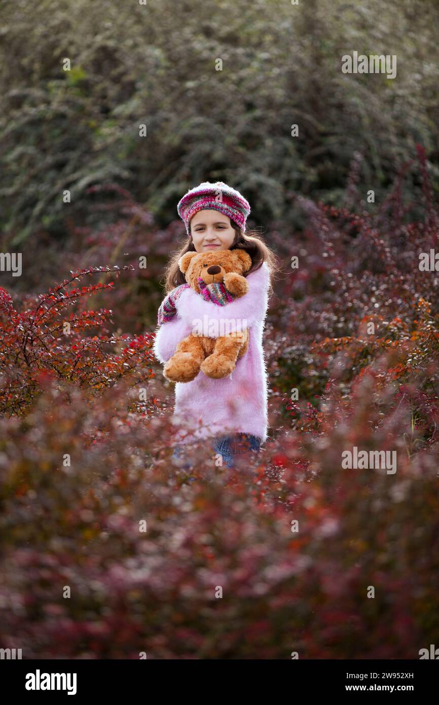 Ein weibliches Kind umarmte ihren Teddybär Stockfoto