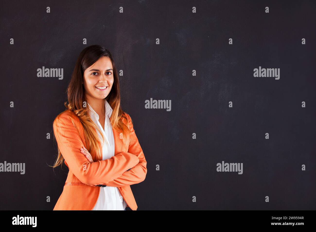 Selbstbewusste Geschäftsfrau neben der Tafel Stockfoto