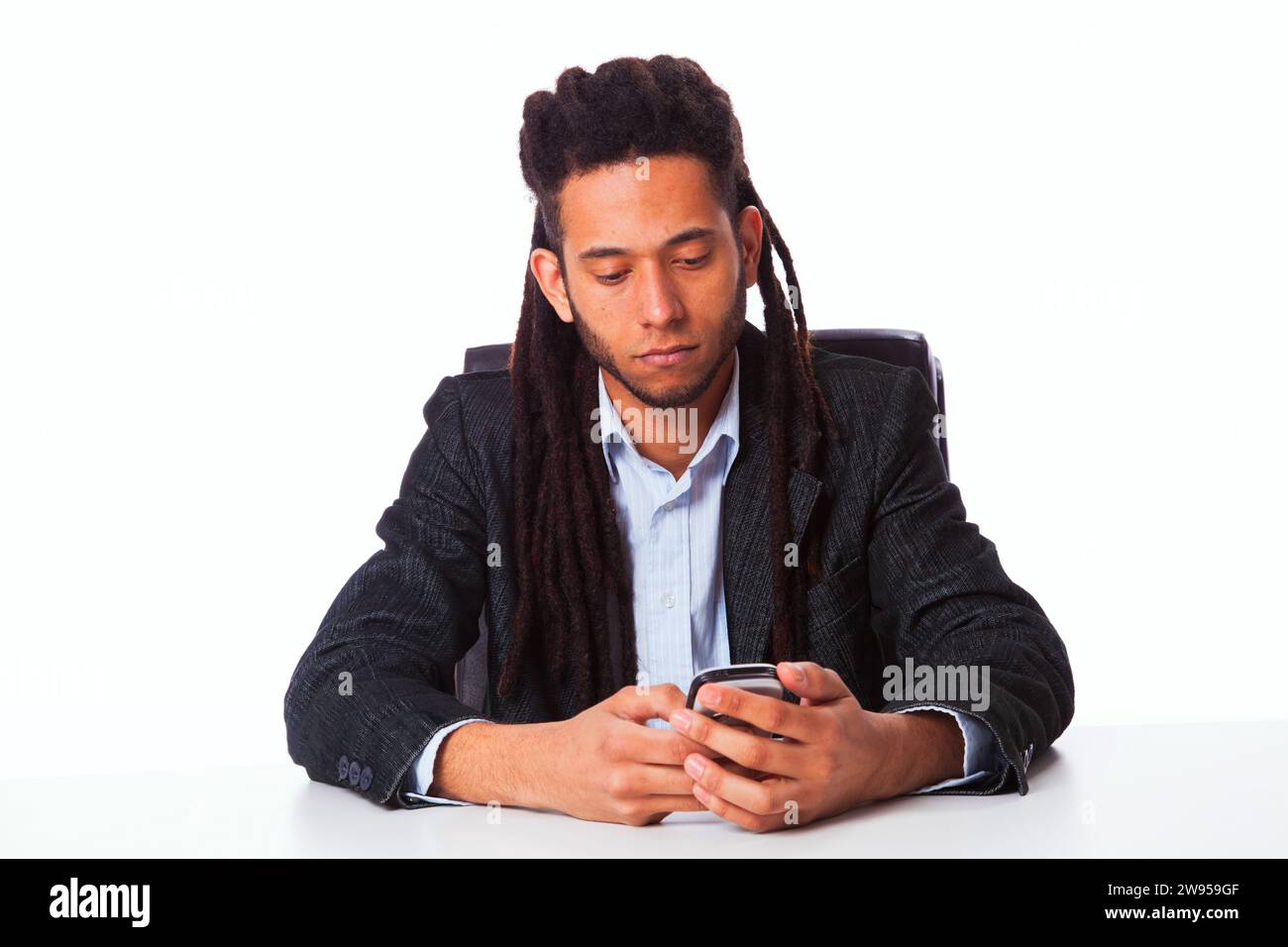 rastafari-Mann hält das Handy in seinem Büro Stockfoto