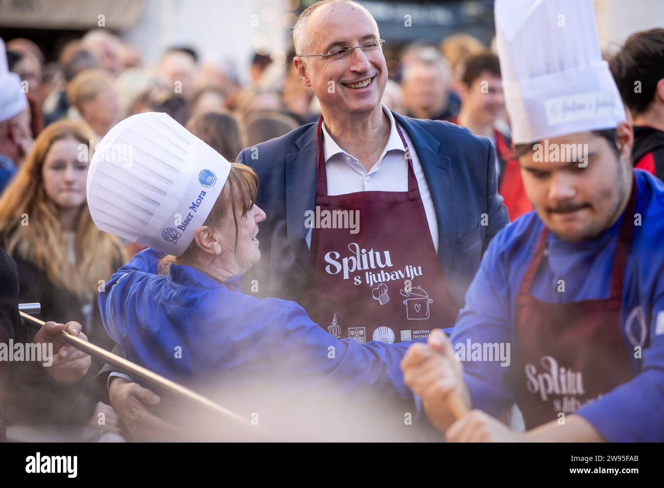 Kroatien, Split 241223. Etwa fünftausend Portionen Kabeljau und die gleiche Anzahl von Krapfen wurden in Peskaria in Split im Rahmen des Split with Love Events verteilt, das traditionell am Heiligabend stattfindet. Auf dem Foto: Jagoda Nikolic i Ivica Puljak Foto: SASA Buric / CROPIX Copyright: XSasaxBuricx/xCROPIXxSasaxBuricx bakalar peskarija bozic19-241223 Stockfoto