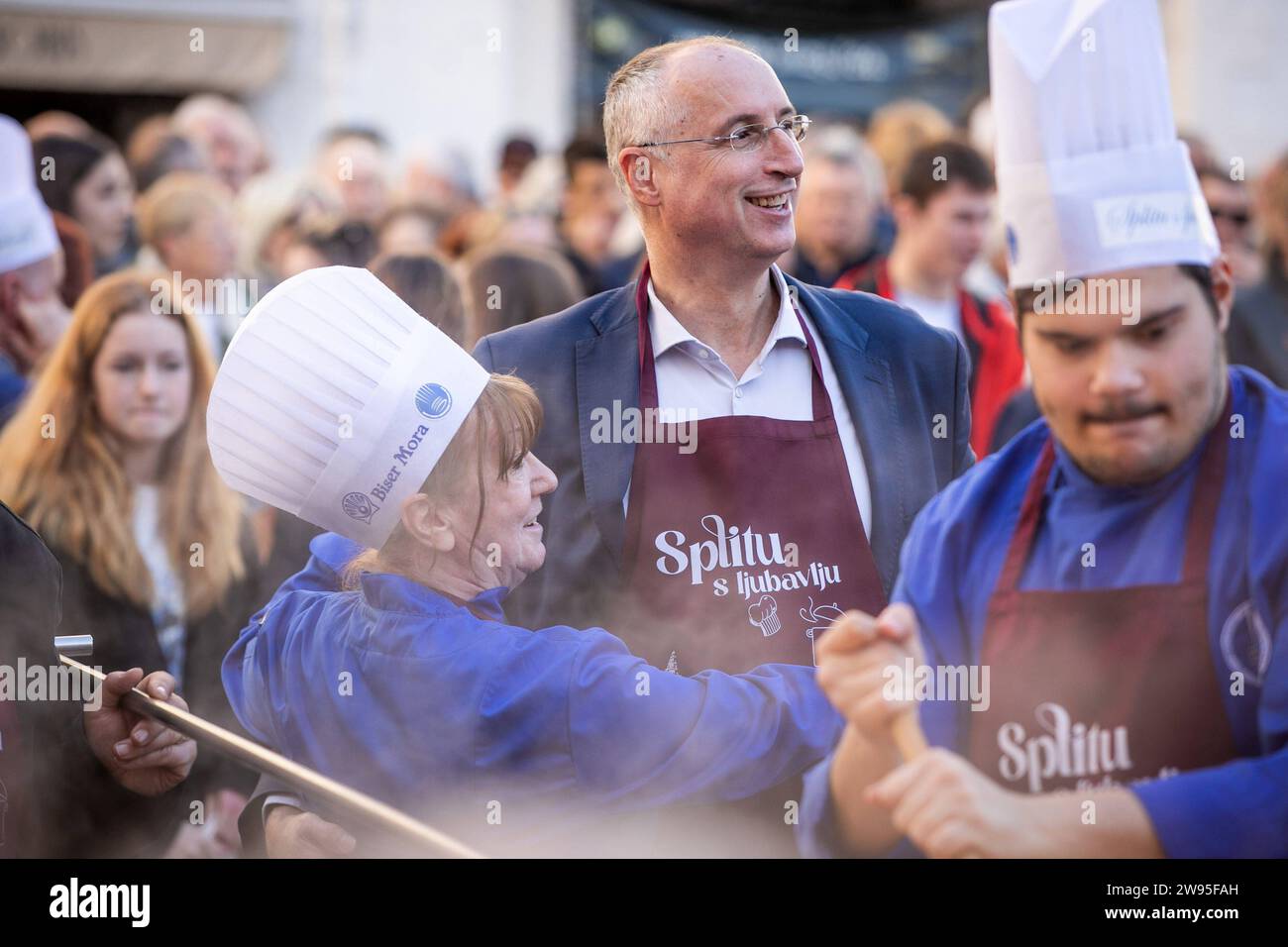 Kroatien, Split 241223. Etwa fünftausend Portionen Kabeljau und die gleiche Anzahl von Krapfen wurden in Peskaria in Split im Rahmen des Split with Love Events verteilt, das traditionell am Heiligabend stattfindet. Auf dem Foto: Jagoda Nikolic i Ivica Puljak Foto: SASA Buric / CROPIX Copyright: XSasaxBuricx/xCROPIXxSasaxBuricx bakalar peskarija bozic20-241223 Stockfoto