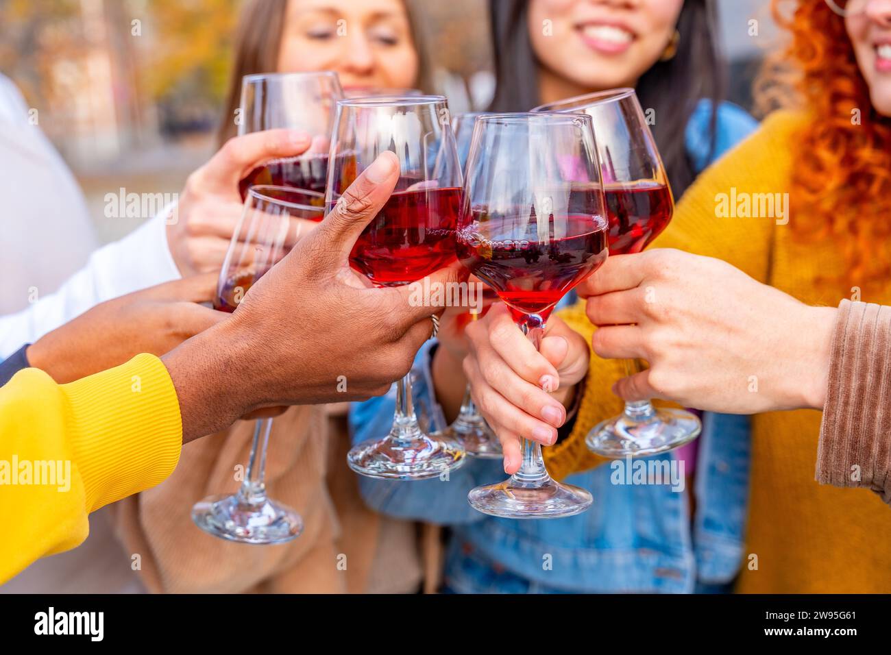 Nahaufnahme von Freunden, die auf der Straße der Stadt feiern und mit Wein rösten Stockfoto