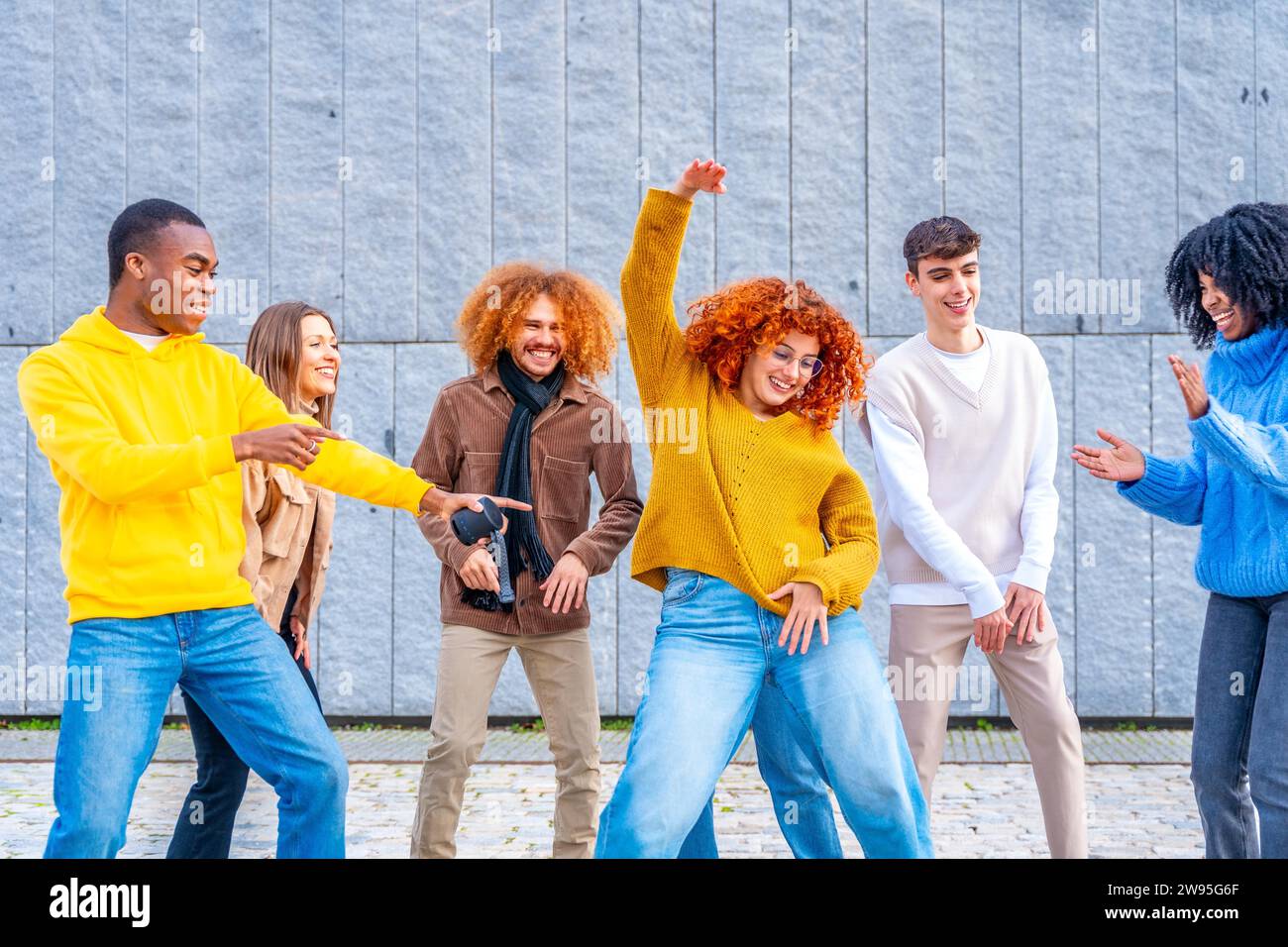 Vielfältige und multiethnische Freunde feiern und tanzen auf der Straße Stockfoto