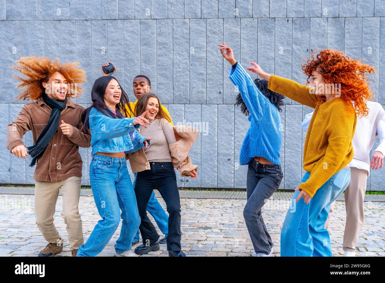 Multi-ethnische glückliche Freunde tanzen aufgeregt in der Stadt zusammen Stockfoto