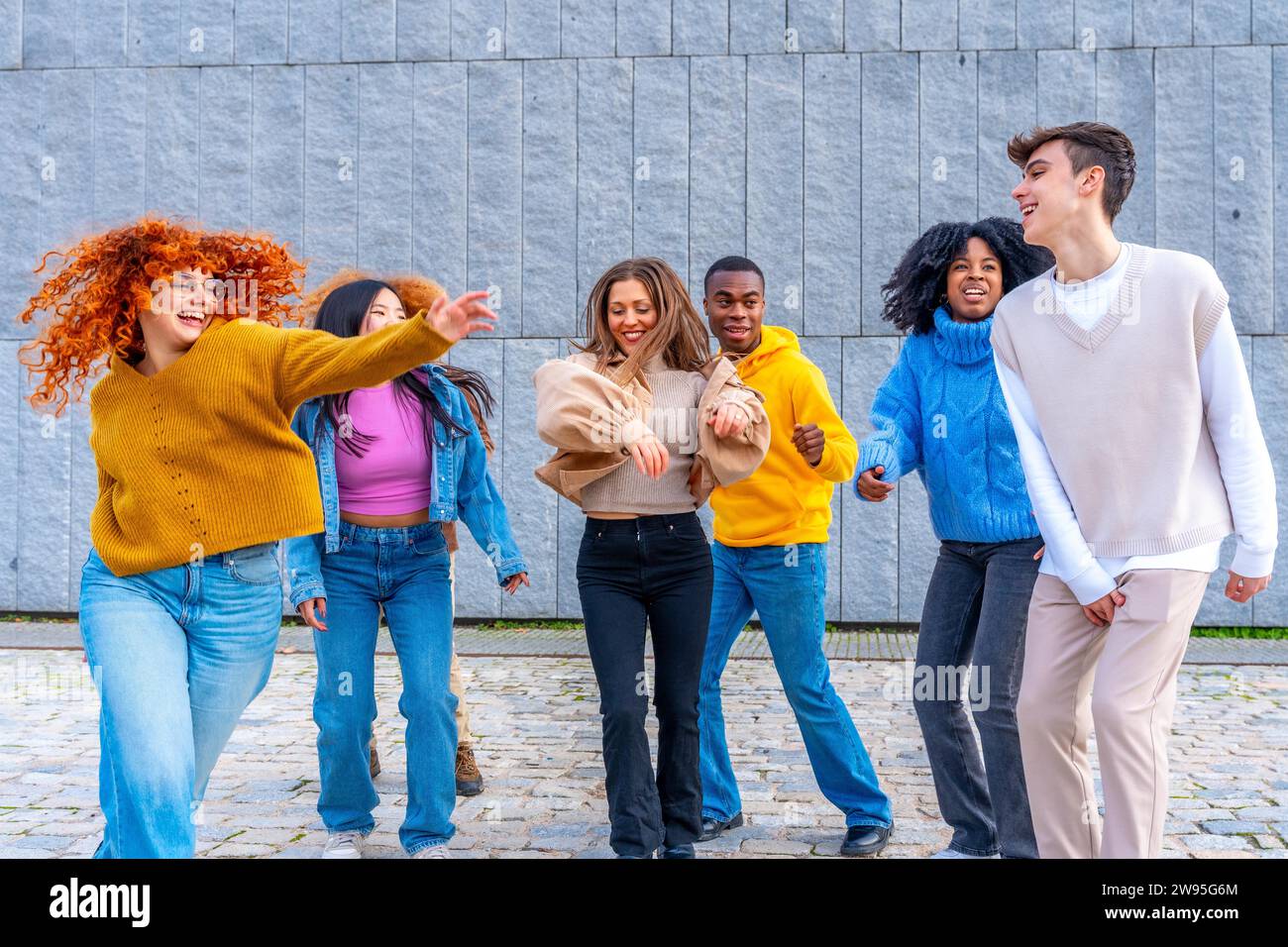 Freier Tanz von fröhlichen multiethnischen und vielfältigen Freunden auf der Straße Stockfoto