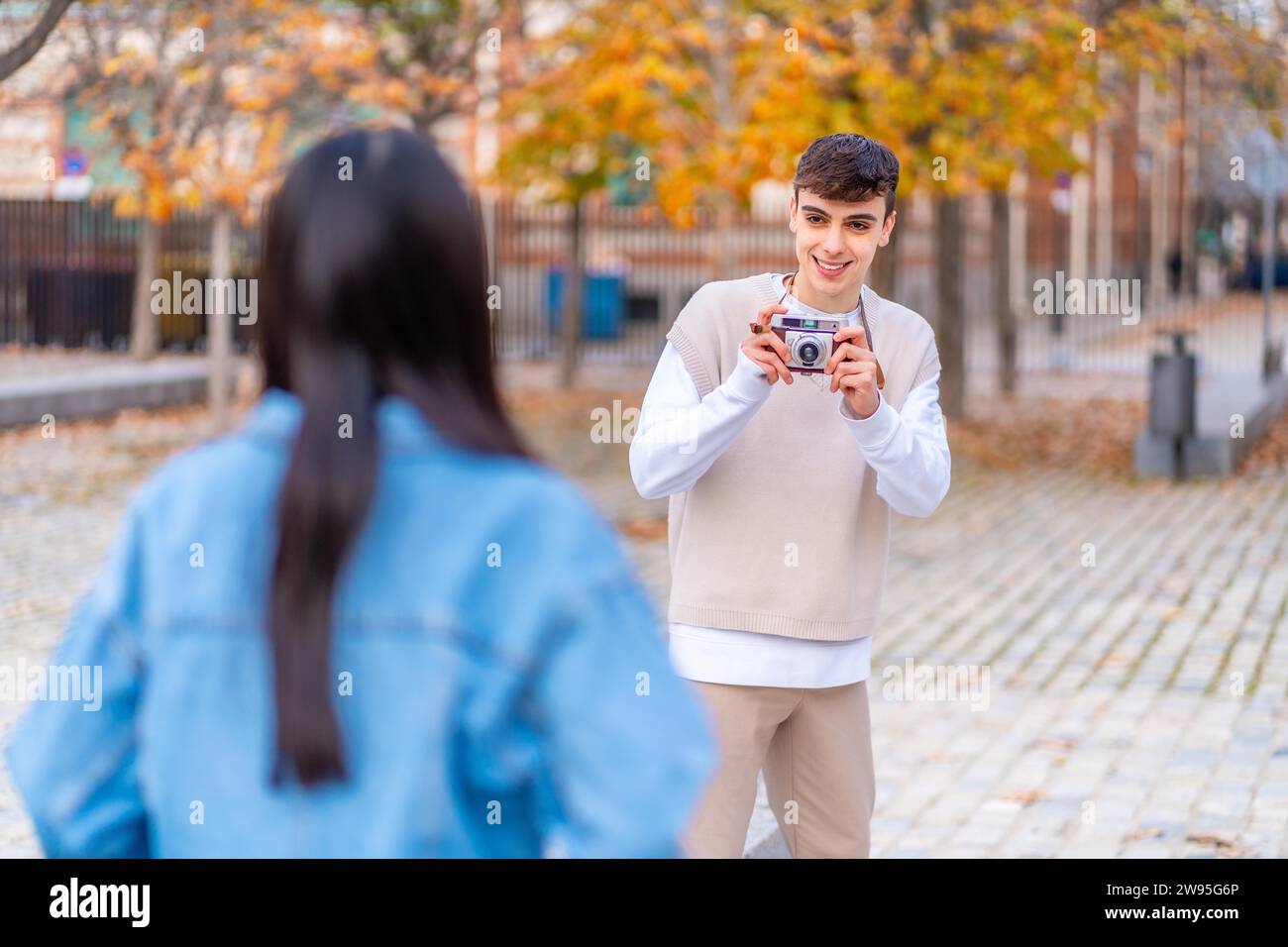 Ein junger Mann, der ein Foto mit einer Digitalkamera macht, an einen Freund in der Stadt Stockfoto