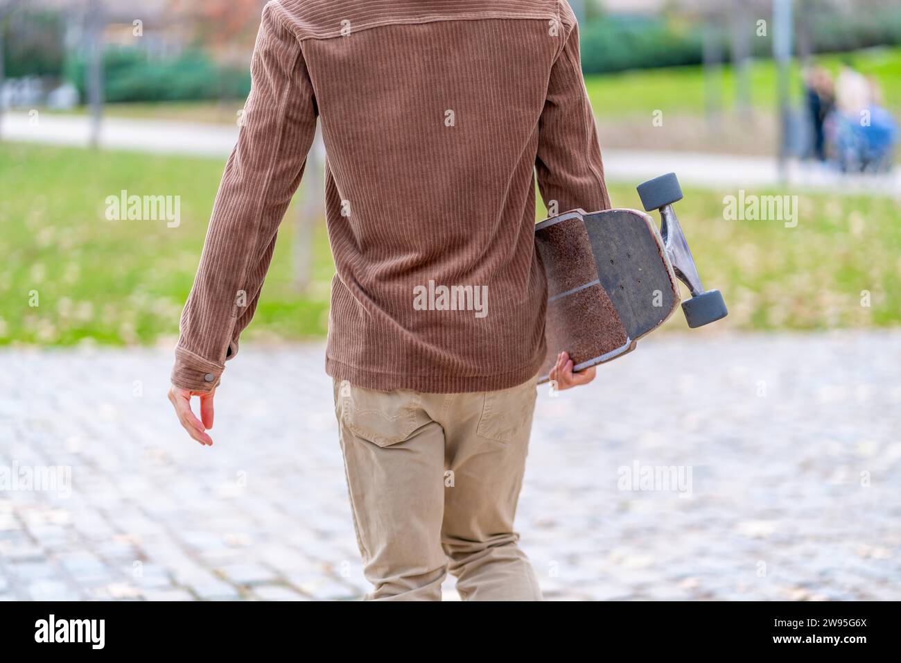 Rückansicht eines nicht erkennbaren Skaters, der zu einem urbanen Park läuft Stockfoto