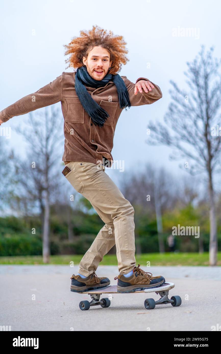Man läuft und beweist Gleichgewicht in einem Skateboard in einem urbanen Park Stockfoto