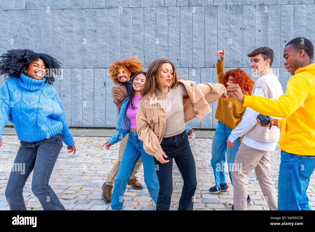 Multiethnische junge, vielfältige Freunde, die gemeinsam auf der Straße tanzen Stockfoto