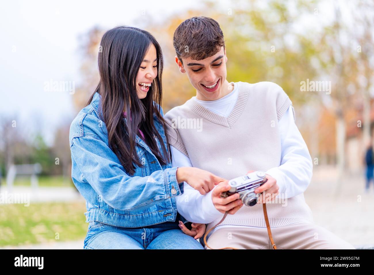 Junge Menschen, die Fotos auf dem Bildschirm einer Digitalkamera sehen Stockfoto