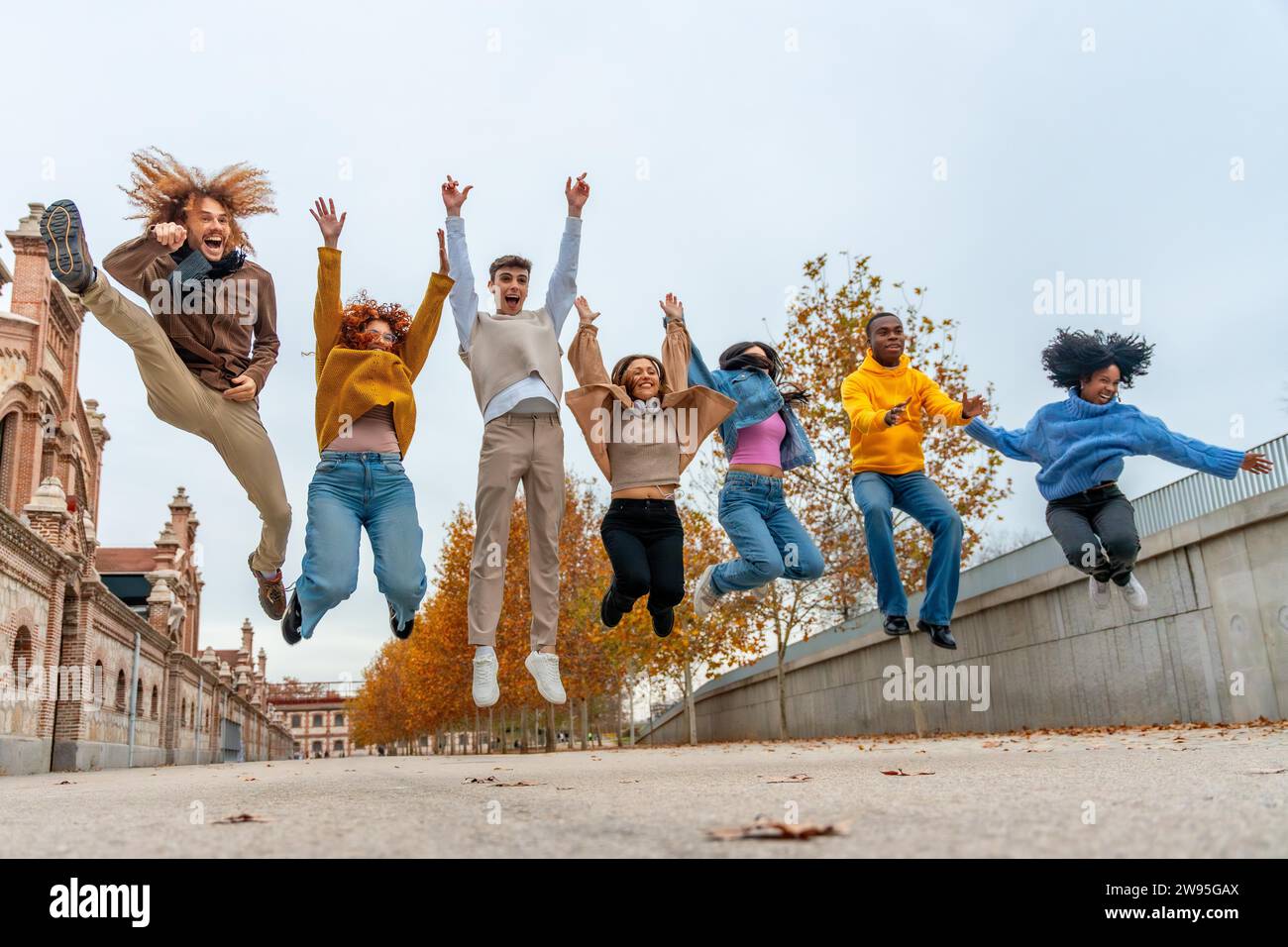 Low-Winkels-Foto einer Gruppe multiethnischer Freunde, die in einem Stadtpark springen Stockfoto