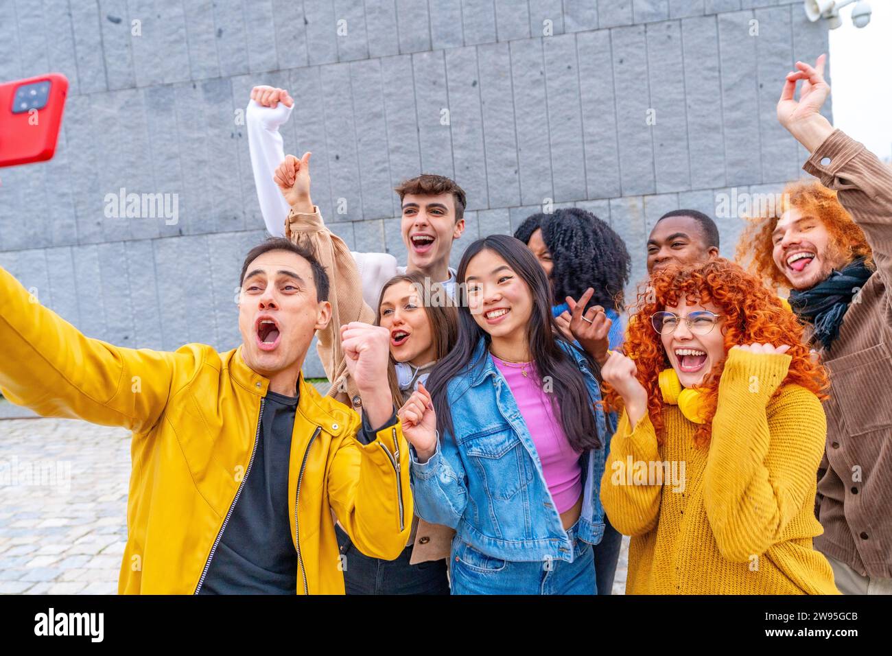 Eine aufgeregte Gruppe von multiethnischen Freunden feiert, während sie ein Selfie im Freien macht Stockfoto
