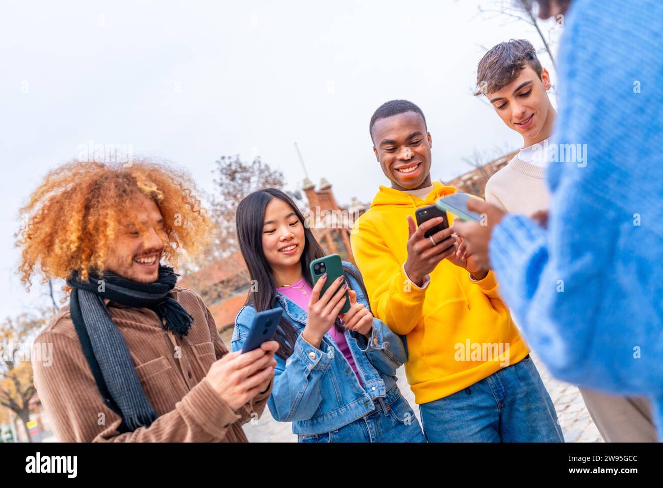 Dynamische Aufnahme multiethnischer Freunde mit Telefon in der Stadt Stockfoto
