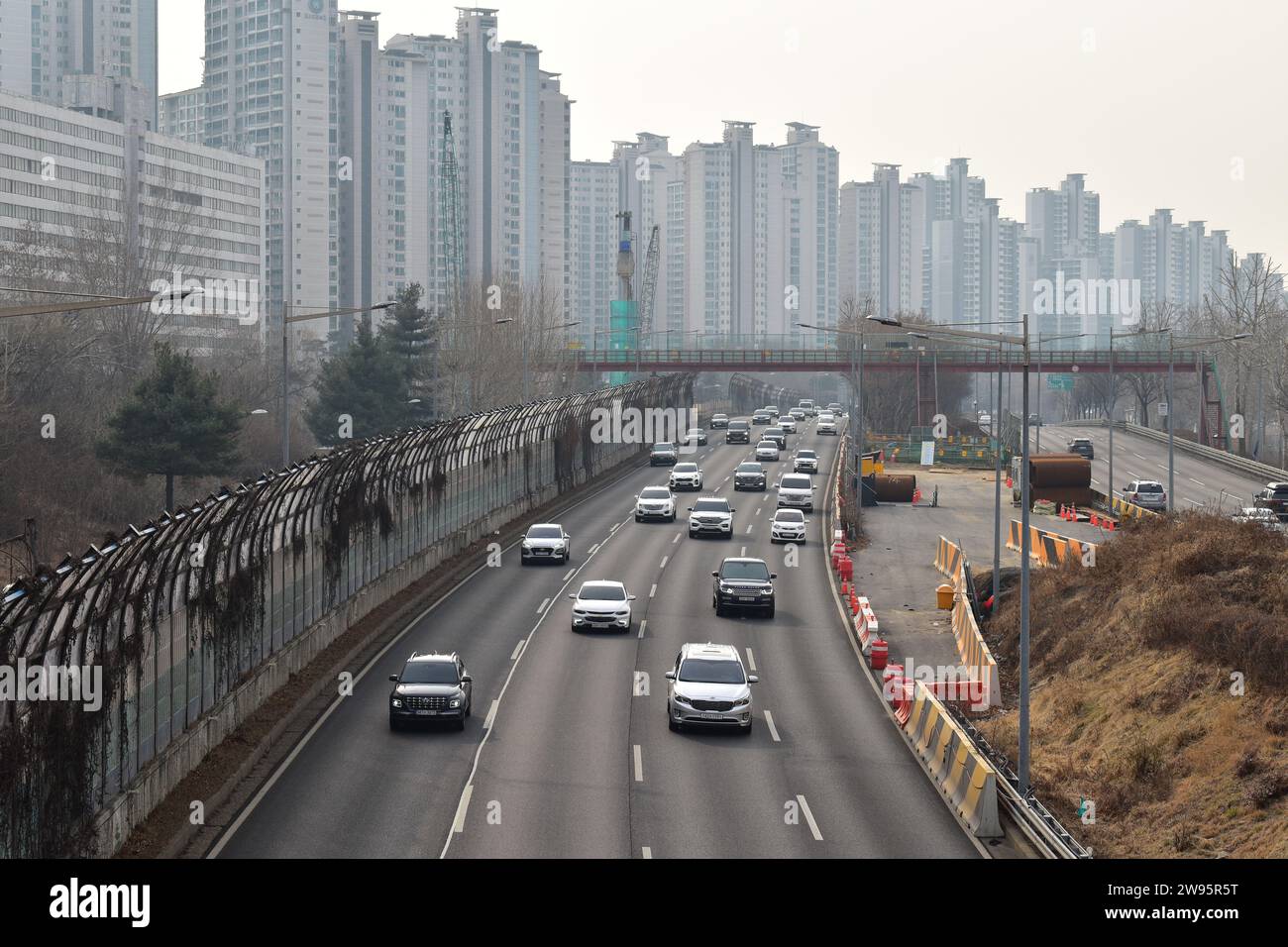 Autos, die den Olympic-Daero Highway entlang fahren, umgeben von hohen Wohnhäusern im Bezirk Songpa Stockfoto