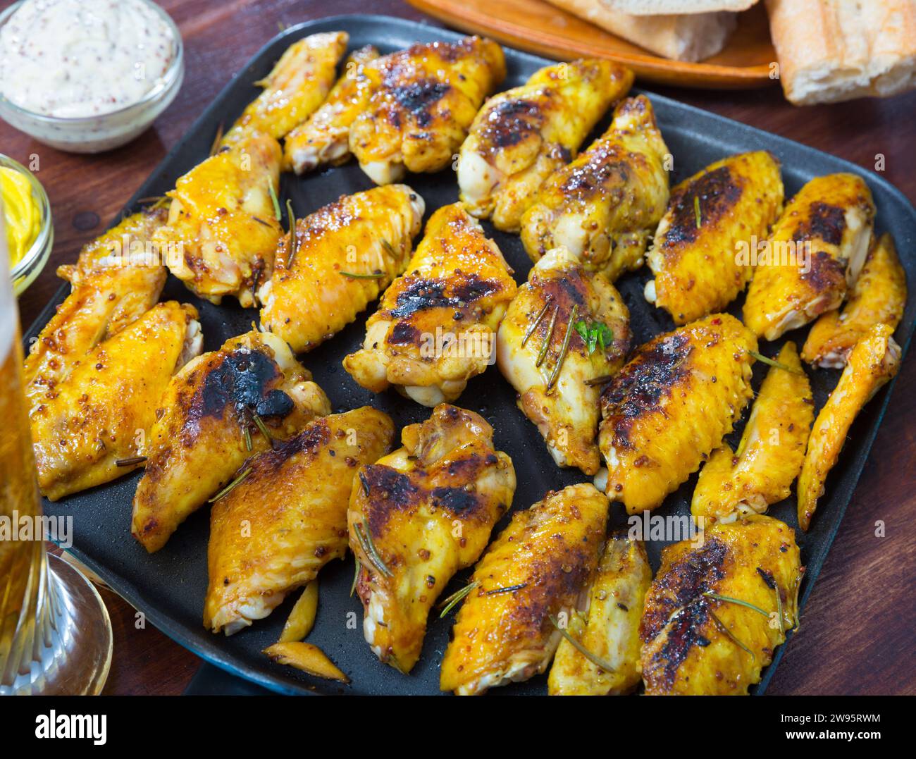 Gebratene Hähnchenflügel auf der Grillpfanne mit Sauce Stockfoto