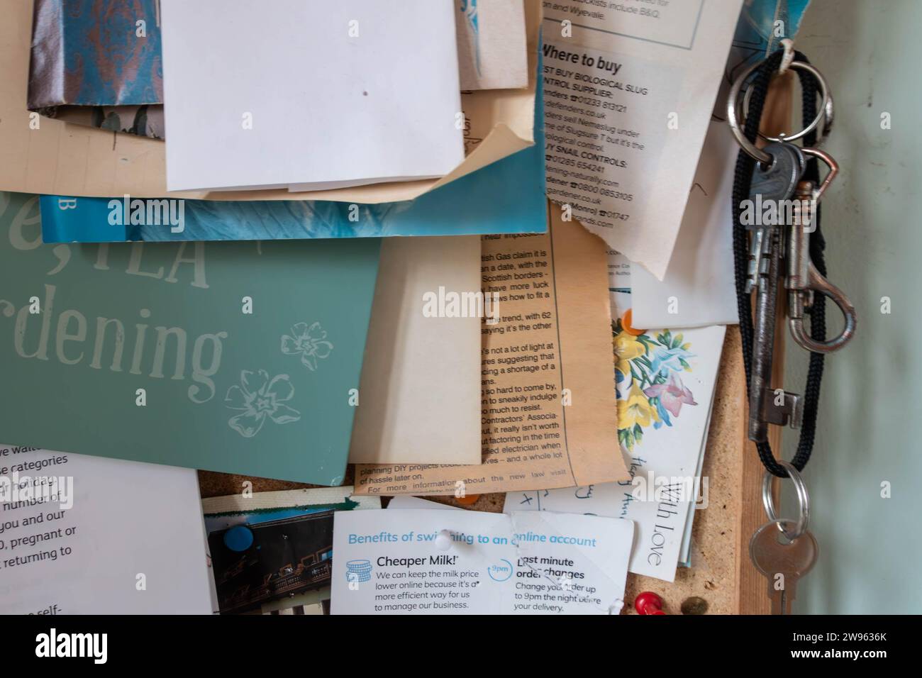 Eine Korktafel mit Briefen, Informationen und Hinweisen, die an Ort und Stelle befestigt sind Stockfoto