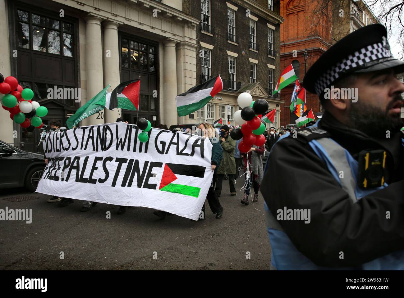 London, Großbritannien. Dezember 2023. Während der Demonstration marschieren Demonstranten hinter einem Banner um den Soho-Platz herum, das besagt: „Schwestern stehen mit Gaza, freies Palästina“. Schwestern Unbeschnittene Unterstützer versammelten sich und marschierten im Londoner West End Einkaufsviertel zur Unterstützung der Palästinenser. Sie verlangten einen dauerhaften Waffenstillstand in Gaza und Kunden, Unternehmen zu boykottieren, die Israel unterstützen. (Foto von Martin Pope/SOPA Images/SIPA USA) Credit: SIPA USA/Alamy Live News Stockfoto