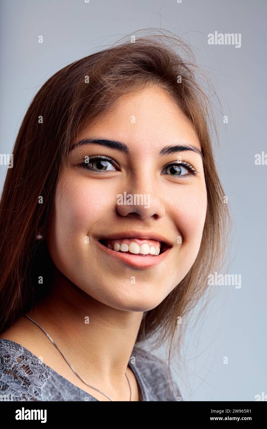 Porträt fängt eine junge Frau mit einem fesselnden Lächeln, braunen Augen und Freizeitkleidung ein Stockfoto