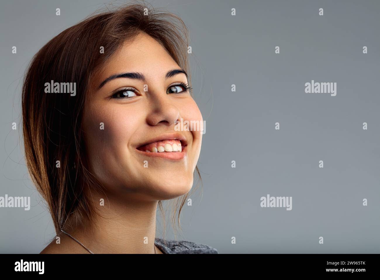 Die fröhliche Aura des Subjekts zeigt sich in ihrem direkten Blick und ihrem leichten Lächeln mit einem ordentlichen Aussehen Stockfoto