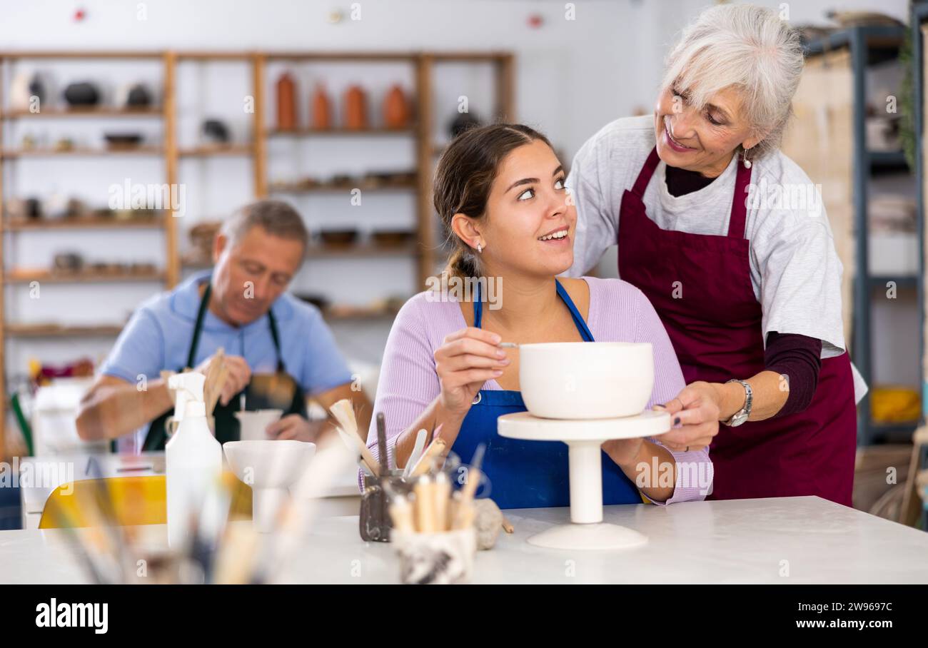 Professionelle Töpferinnen lehren junge Frauen Töpferei zu kreieren Stockfoto