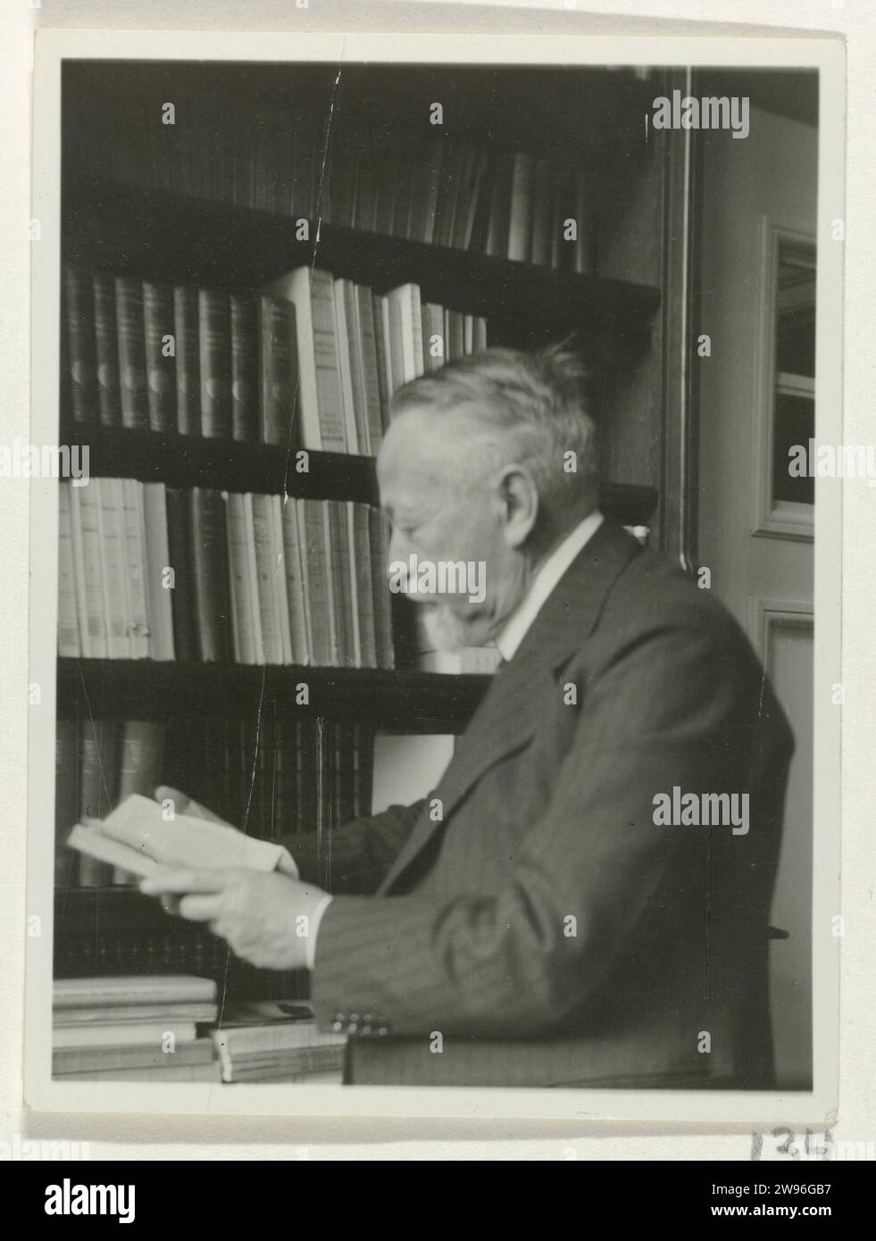 Andries Bonger, im Bücherregal stehend, ein Buch in seinen Händen, Anonym, 1934 Fotopapier. Unterstützung für Fotos. Gelatine Silberdruck aus Pappe. Andere Wohnungstypen. Historische Personen Amsterdam Stockfoto