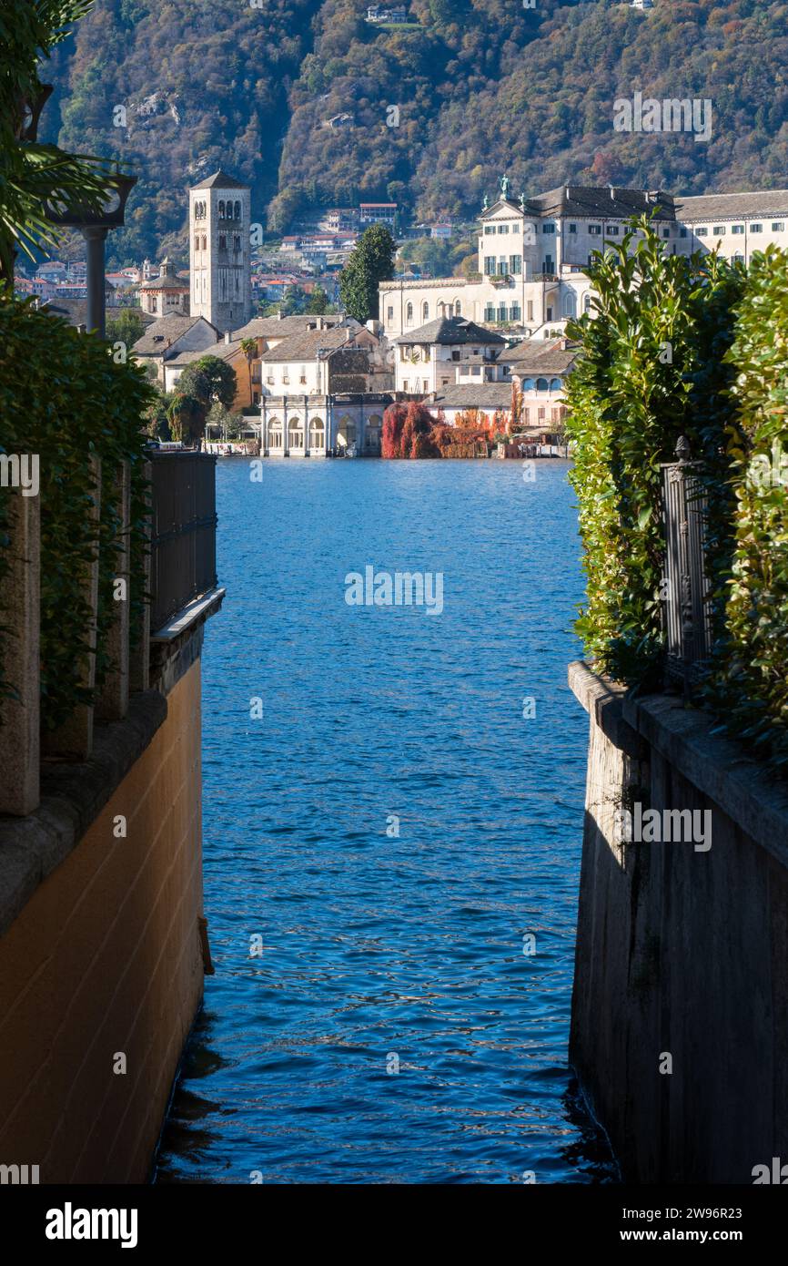 San Giulio Island im Orta-See im Piemont, Italien. Farbenfrohe Berge im Herbst, blaues Wasser, Kirche, Kloster und andere Gebäude Stockfoto