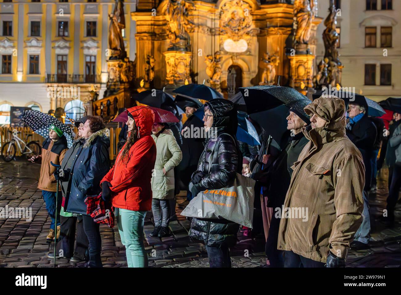 Olomouc, Tschechische Republik. Dezember 2023. Christliche Gläubige nehmen an einer Mitternachtsmesse unter freiem Himmel auf dem Oberen Platz in Olmütz Teil. Die Mitternachtsmesse ist die erste Liturgie der Weihnachtszeit, die von Christen in der Nacht des Heiligabends auf der ganzen Welt gefeiert wird. Der obere Platz (Horni namesti auf Tschechisch) ist der historische Platz in Olmütz mit der Dreifaltigkeitssäule, die zum UNESCO-Weltkulturerbe gehört. (Foto: Tomas Tkacik/SOPA Images/SIPA USA) Credit: SIPA USA/Alamy Live News Stockfoto