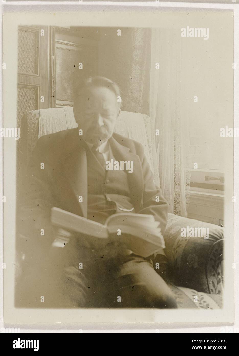 Andries Bonger, in Leunstoel, liest ein Buch, Anonym, 1910 - 1930 Fotopapier. Unterstützung für Fotos. Gelatine Silberdruck aus Pappe. Andere Wohnungstypen. Historische Personen Amsterdam Stockfoto