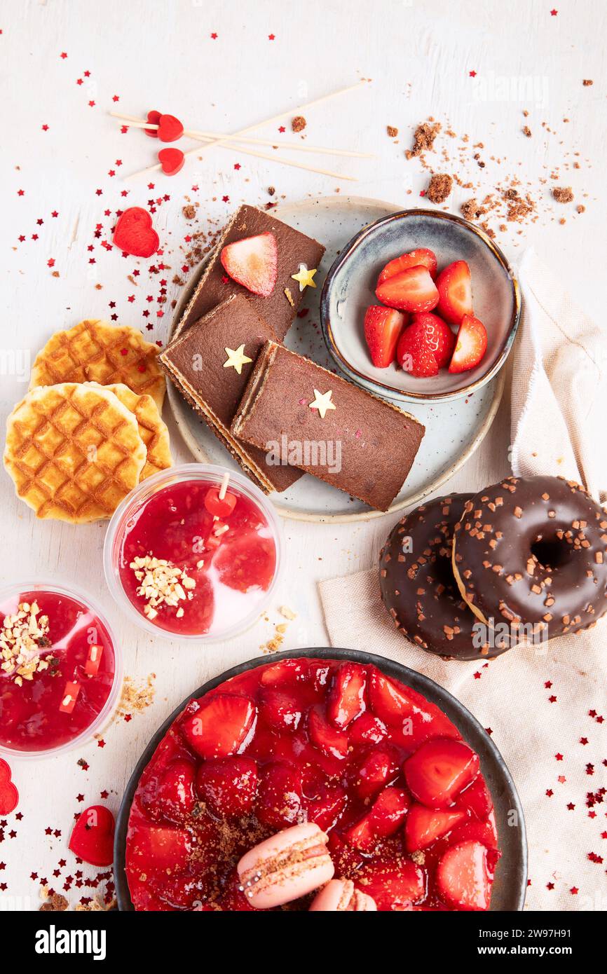 Dessert zum Valentinstag. Mothers Day Dessert. Tageskuchen für Damen. Verschiedene Süßigkeiten auf weißem Hintergrund. Draufsicht. Stockfoto