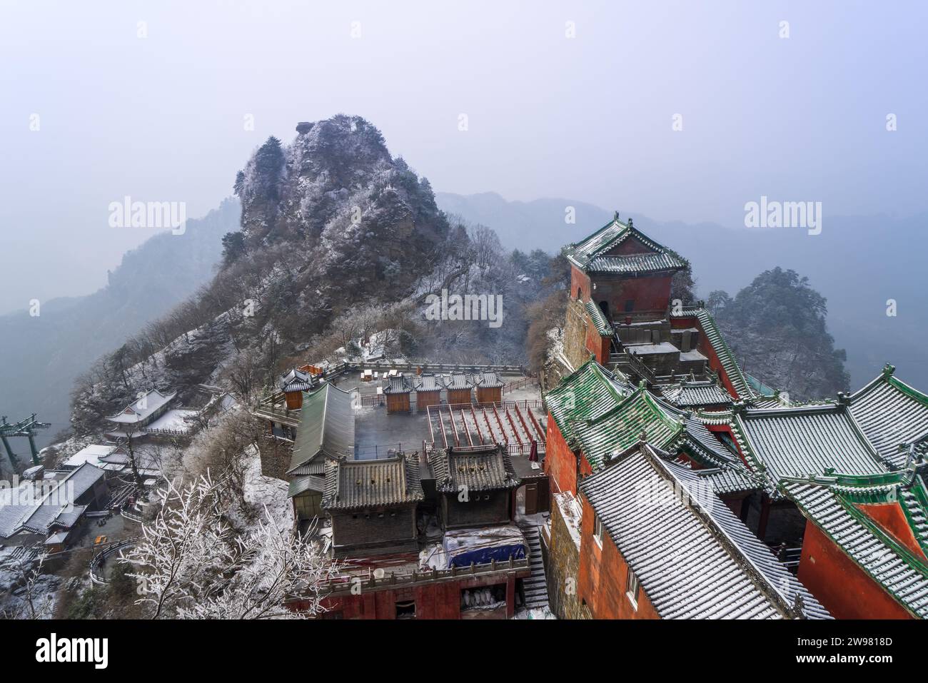 Antike Gebäude in Chinas Wudang-Bergen sind elegant mit einer Schneeschicht dekoriert und bieten eine harmonische Mischung aus Natur und Architektur. Stockfoto