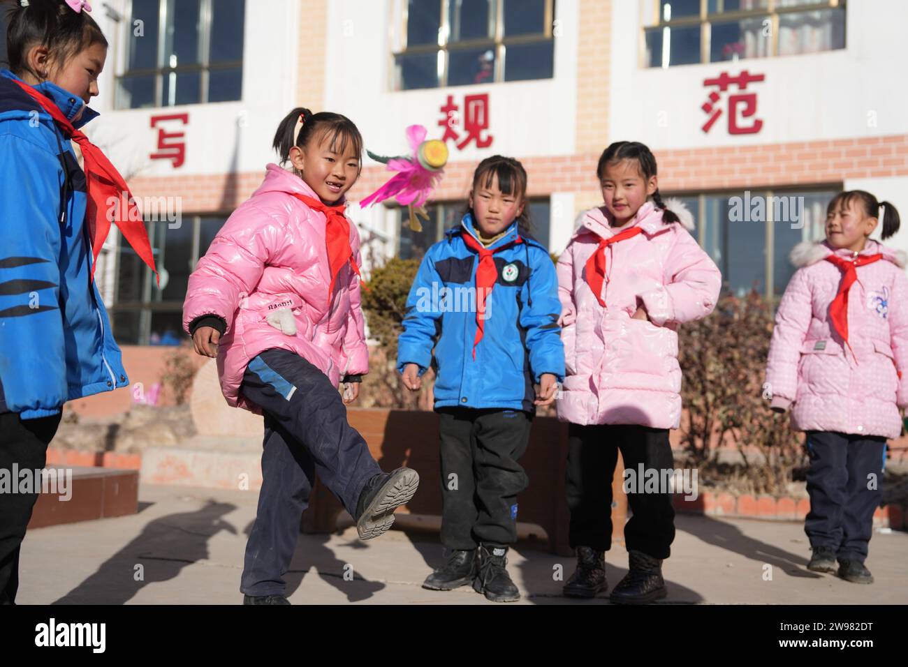 Jishishan, Chinas Provinz Gansu. Dezember 2023. Die Schüler spielen Spiele während einer Klassenpause in einer Grundschule in der Gemeinde Liugou im Jishishan County, nordwestchinesische Provinz Gansu, 25. Dezember 2023. Grund- und Sekundarschulen in den von Erdbeben betroffenen Gebieten von Jishishan begannen am Montag nach einer Sicherheitsüberprüfung wieder den Unterricht aufzunehmen. Quelle: Chen Bin/Xinhua/Alamy Live News Stockfoto