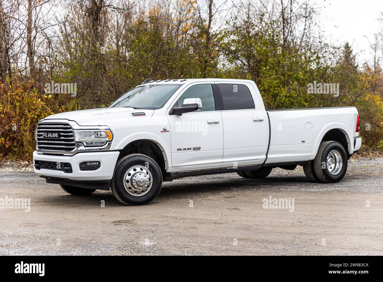 Ein weißer RAM-Pickup steht auf einem Parkplatz, eingebettet vor einem Hintergrund von bewaldetem Gelände Stockfoto