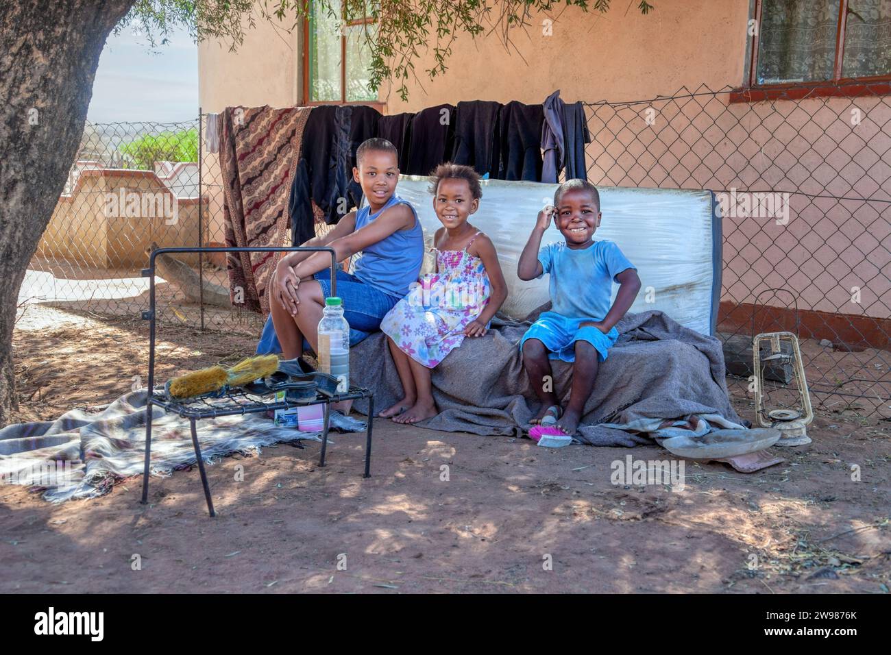Gruppe afrikanischer Kinder im Dorf, die vor dem Haus spielen Stockfoto