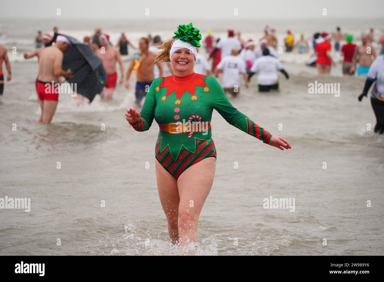 Schwimmer nehmen am ersten Weihnachtsfeiertag in Porthcawl, Wales, Teil. Bilddatum: Montag, 25. Dezember 2023. Stockfoto