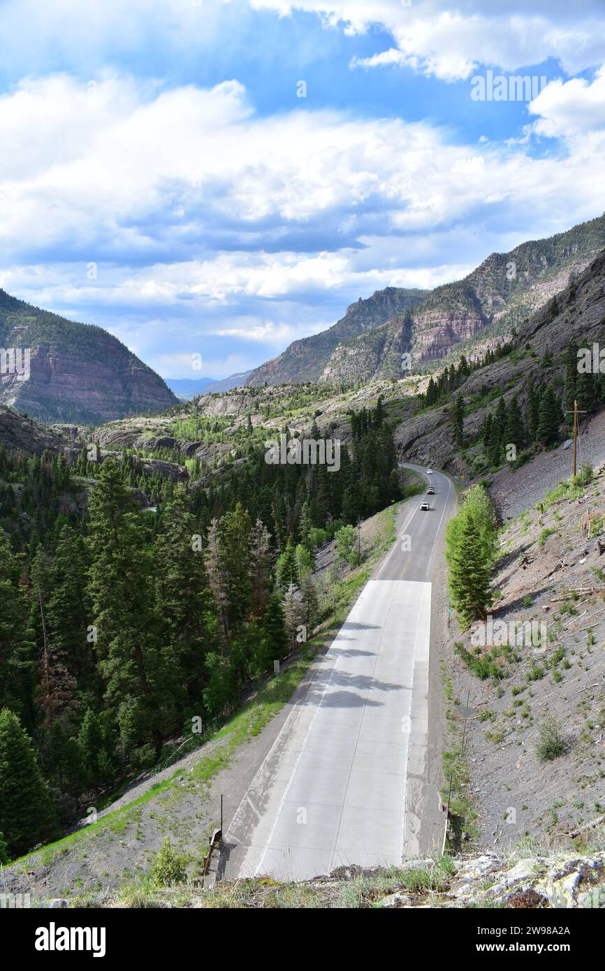 Der Million Dollar Highway schlängelt sich durch das Tal, umgeben von den Rocky Mountains in der Nähe der Bear Creek Falls Stockfoto