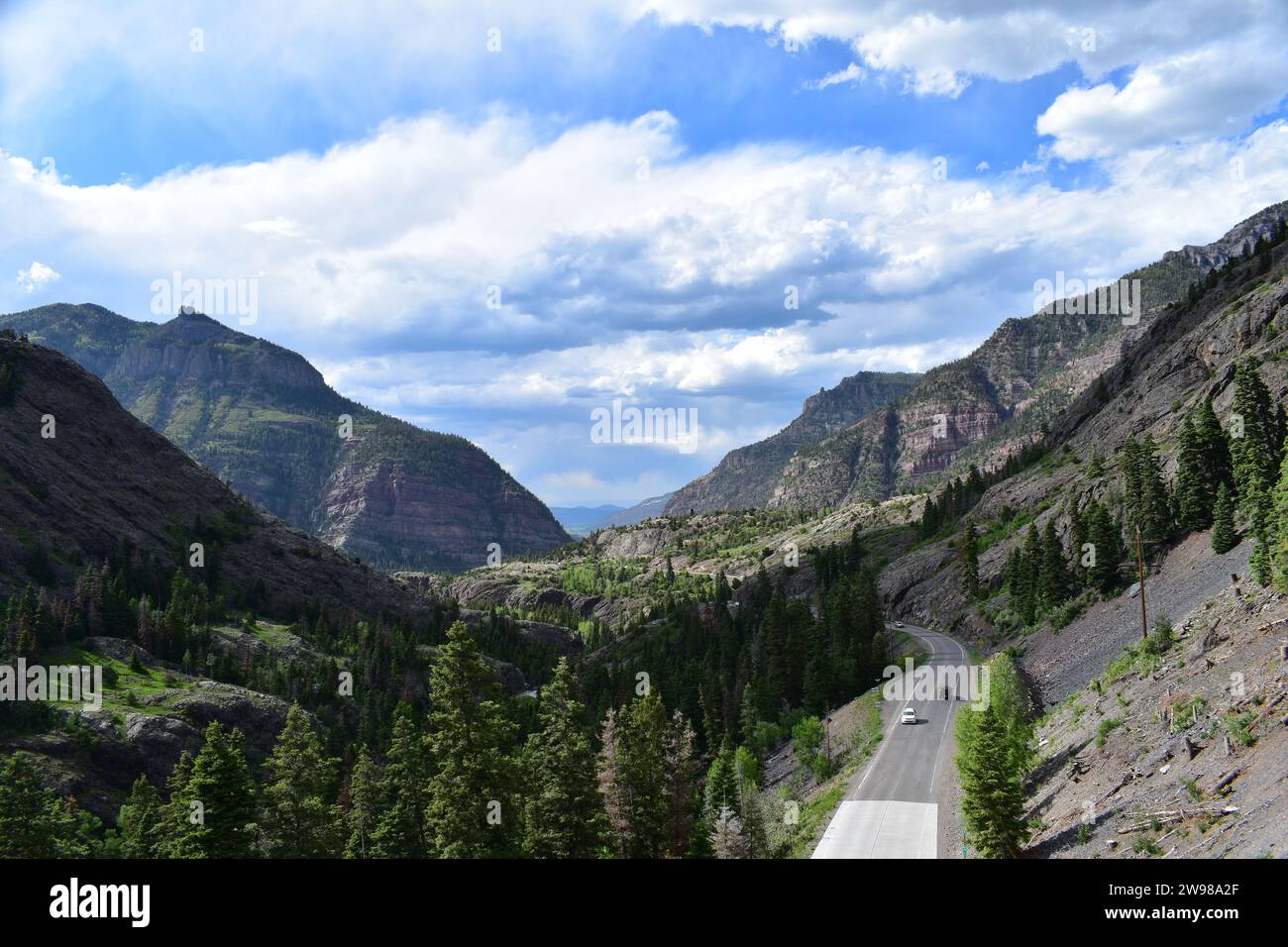 Der Million Dollar Highway schlängelt sich durch das Tal, umgeben von den Rocky Mountains in der Nähe der Bear Creek Falls Stockfoto