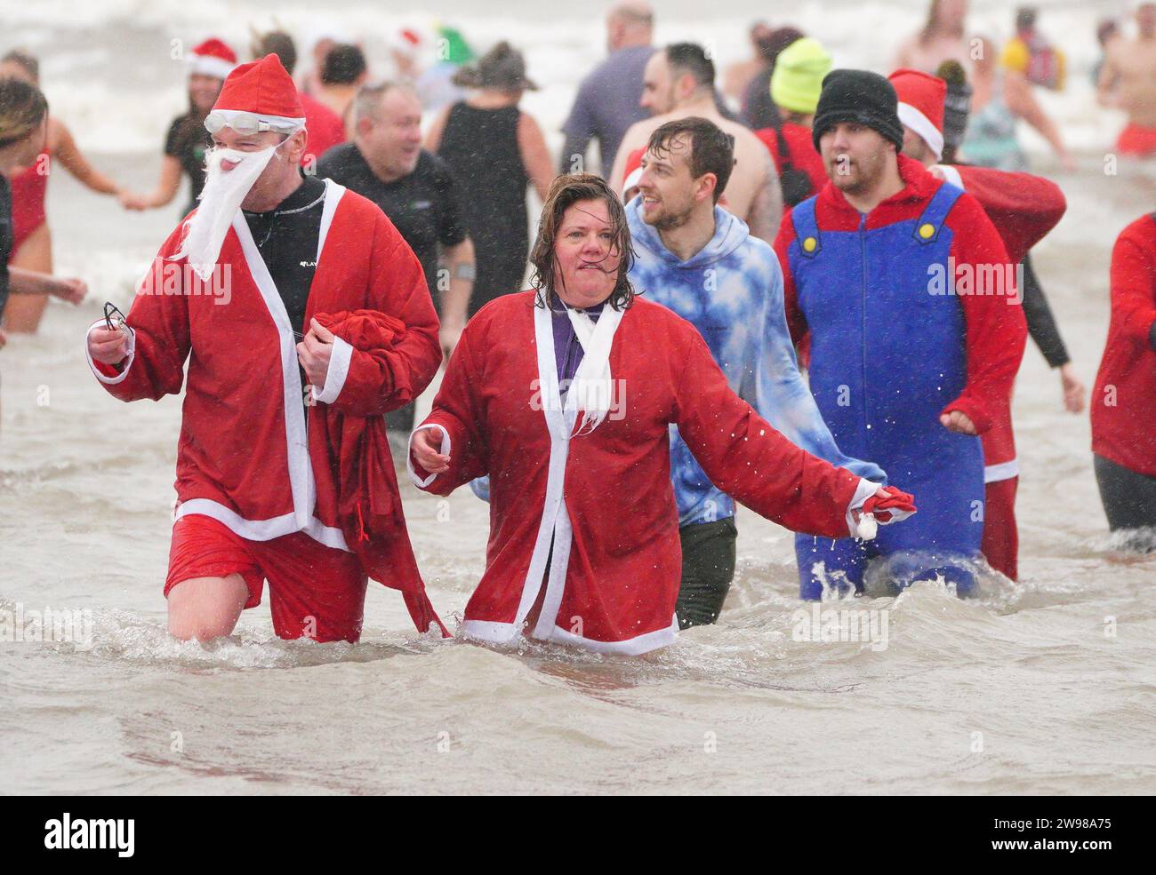 Schwimmer nehmen am ersten Weihnachtsfeiertag in Porthcawl, Wales, Teil. Bilddatum: Montag, 25. Dezember 2023. Stockfoto