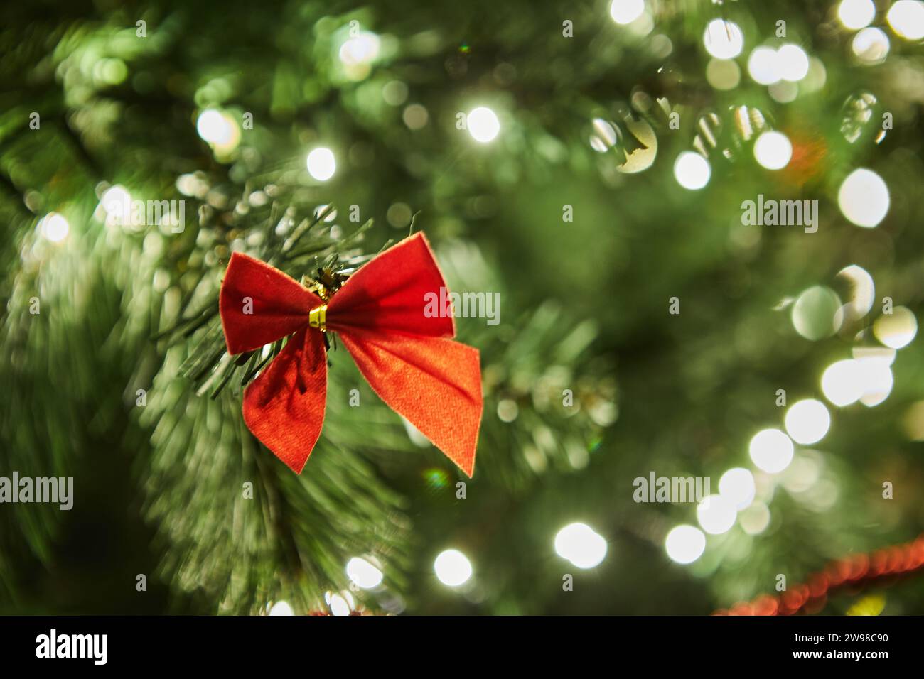 Nahaufnahme eines wunderschön dekorierten Weihnachtsbaums mit bunten Ornamenten, glitzernden Girlanden und leuchtenden Lichtern, die eine festliche und magica schaffen Stockfoto