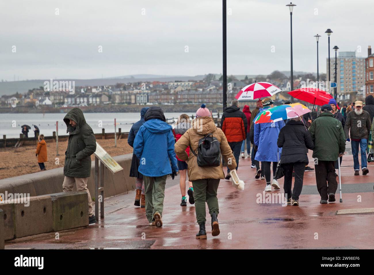 Portobello, Edinburgh, Schottland, Großbritannien. 25. Dezember 2023. Wetter, Duschen am Weihnachtsfeiertag, Sonnenschirme wurden auf der Promenade benutzt, um auf dem Porty-Abschlussball am Firth of Forth spazieren zu gehen. Temperatureinstellung 8 Grad Celsius. Quelle: Archwhite/Alamy Live News. Stockfoto