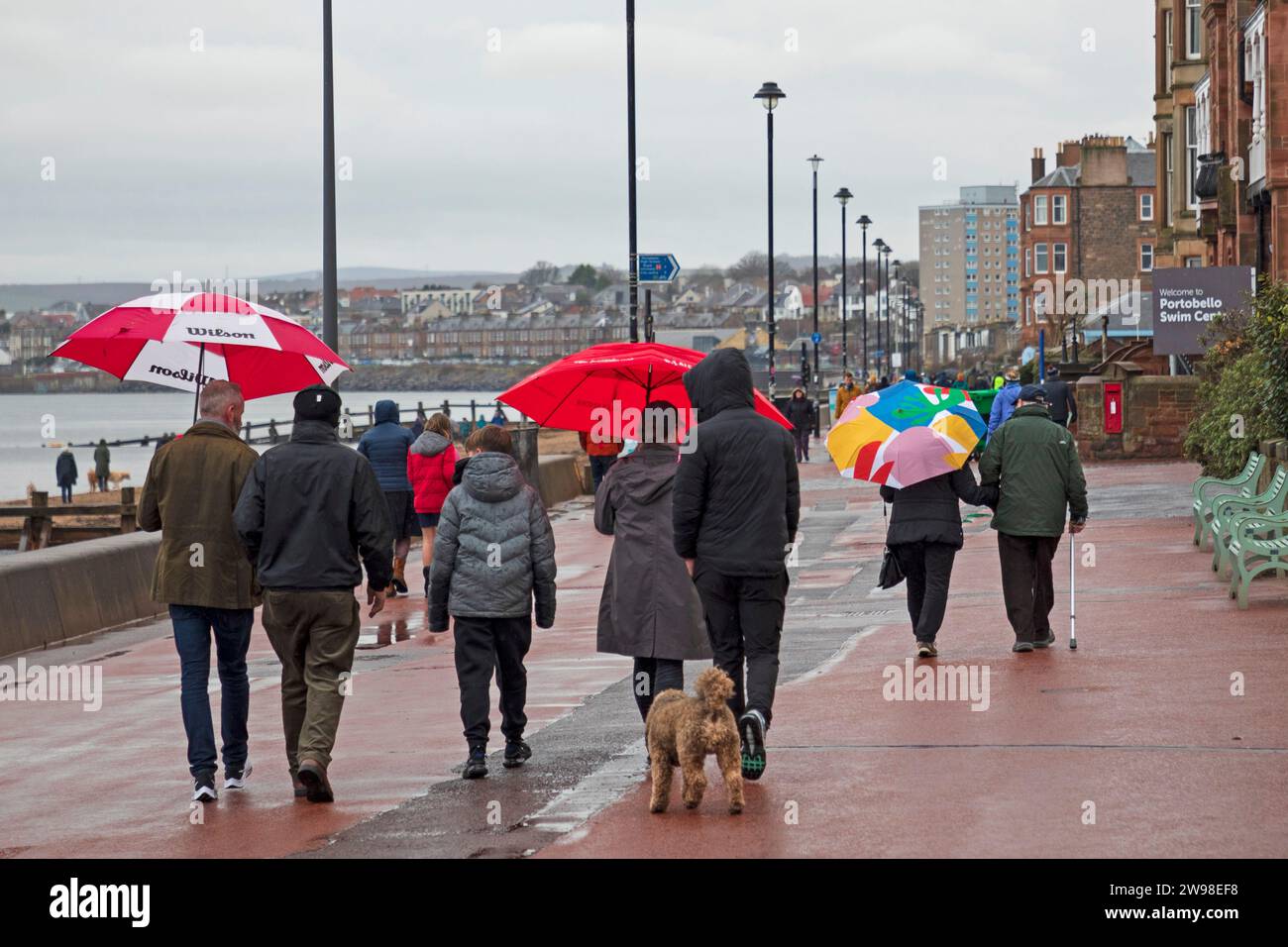 Portobello, Edinburgh, Schottland, Großbritannien. 25. Dezember 2023. Wetter, Duschen am Weihnachtsfeiertag, Sonnenschirme wurden auf der Promenade benutzt, um auf dem Porty-Abschlussball am Firth of Forth spazieren zu gehen. Temperatureinstellung 8 Grad Celsius. Quelle: Archwhite/Alamy Live News. Stockfoto