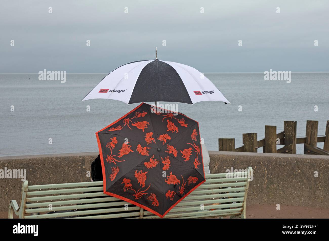 Portobello, Edinburgh, Schottland, Großbritannien. 25. Dezember 2023. Wetter, Duschen am Weihnachtsfeiertag, Sonnenschirme wurden auf der Promenade benutzt, um auf dem Porty-Abschlussball am Firth of Forth spazieren zu gehen. Temperatureinstellung 8 Grad Celsius. Quelle: Archwhite/Alamy Live News. Stockfoto